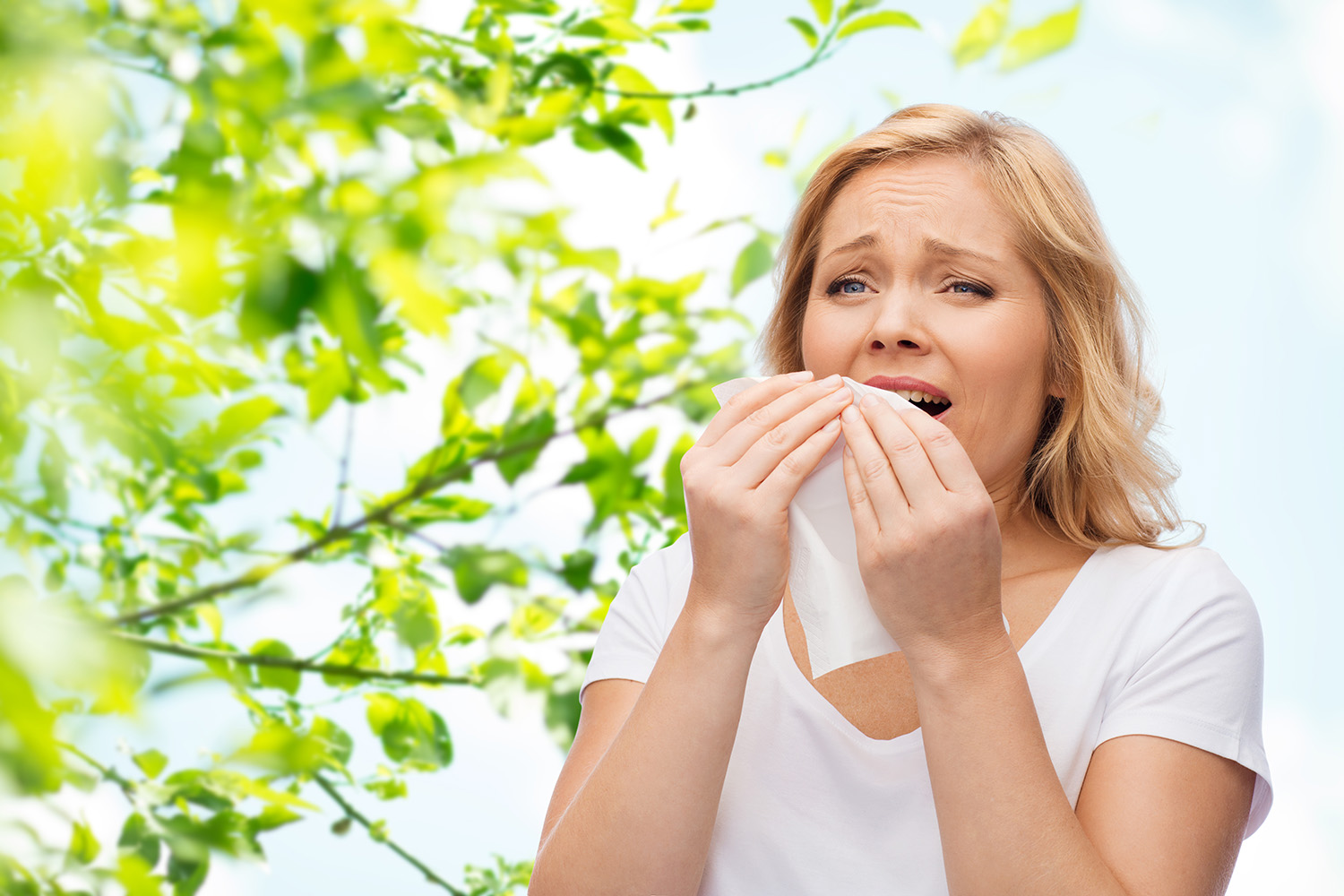 unhappy woman with paper napkin sneezing